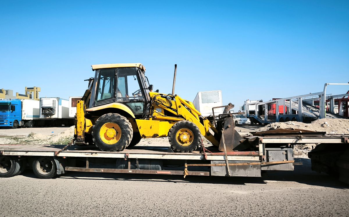 Fahrzeug auf einem Transporter als Symbol fuer Verbringungskosten zur Lackiererei